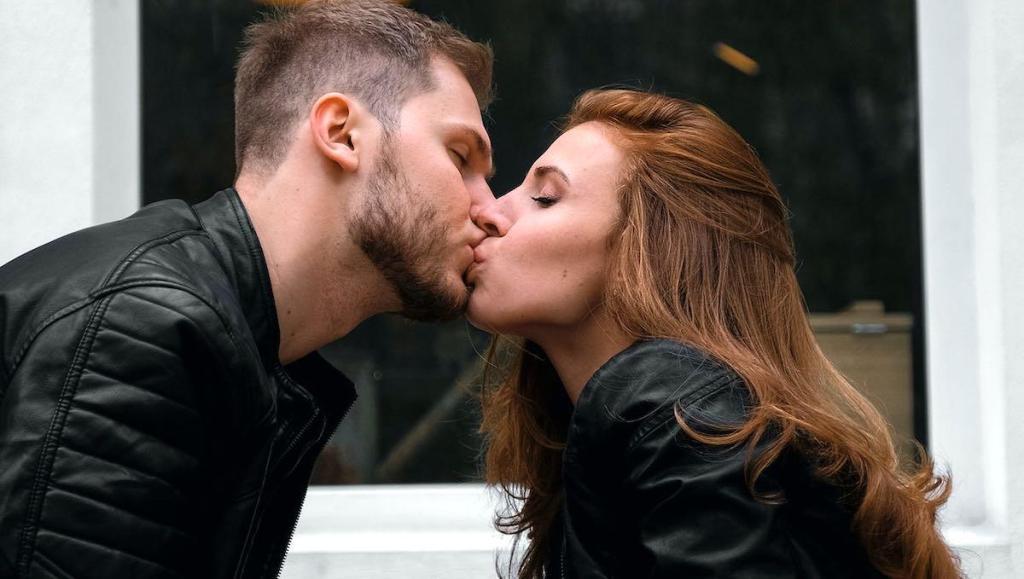 een man en vrouw zoenen voor een café in Nederland