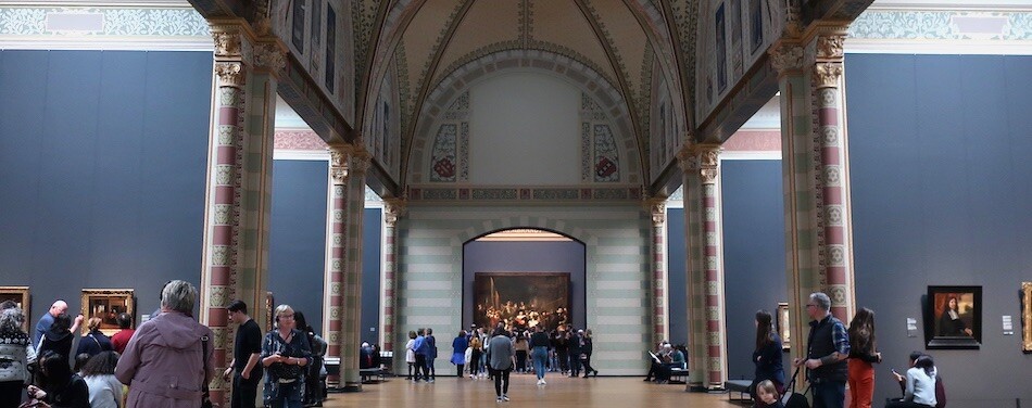 Rijksmuseum from the inside during daytime with visitors on the left and right