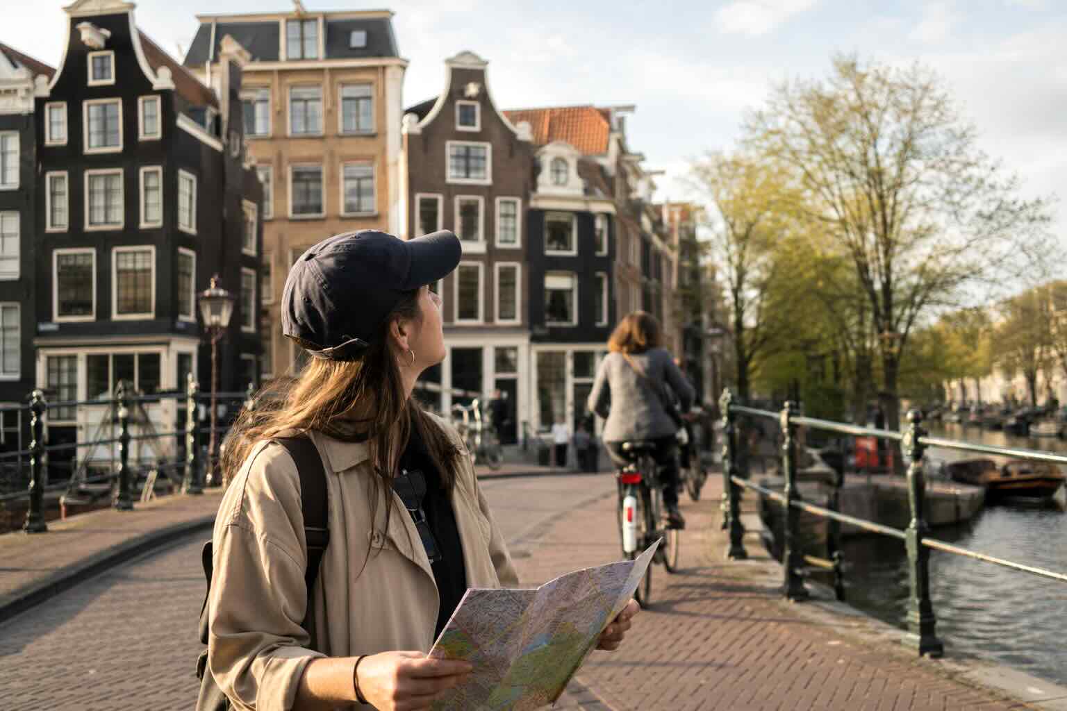 Tourist reading a map of Amsterdam on a canal bridge
